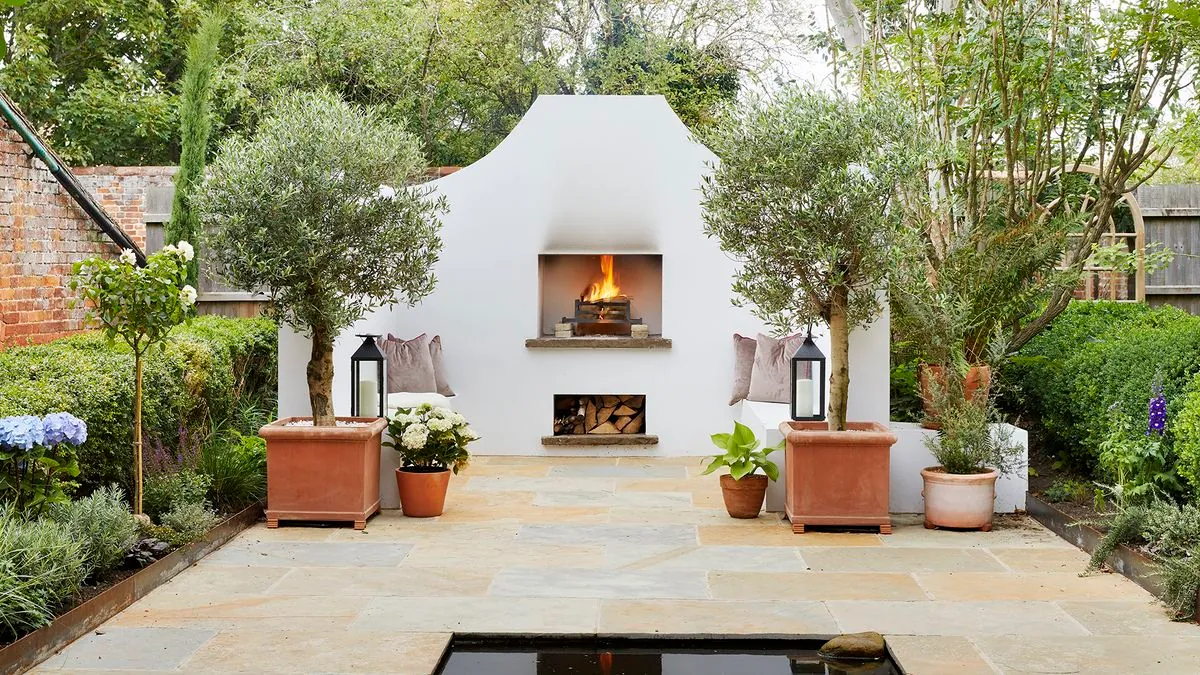 Sandstone patio with outdoor fireplace and olive trees
