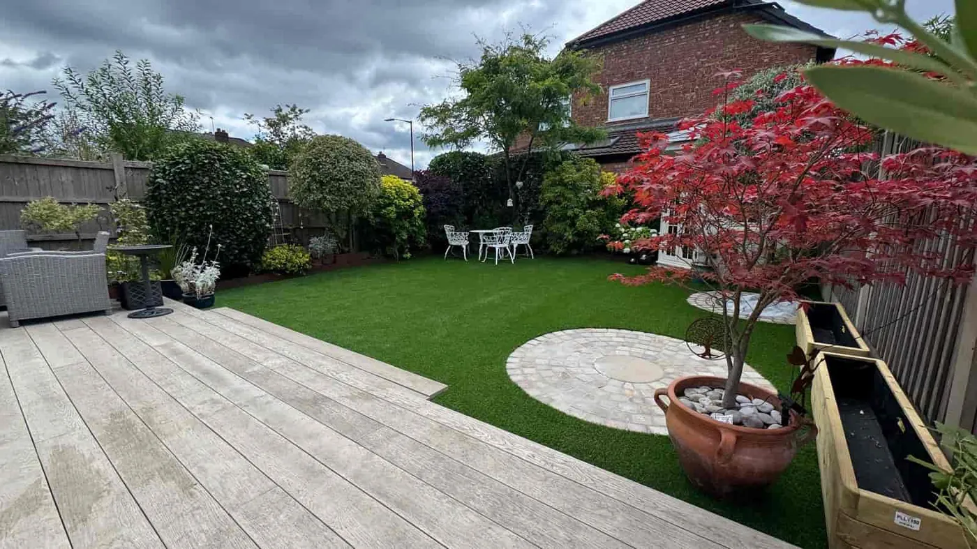 Landscaped garden with artificial lawn, decking and circular paving